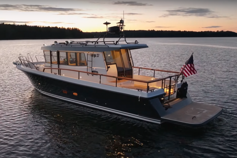 Targa 37 floating with an American flag on the stern just after sundown, with a golden sky and the Maine coast in the background.