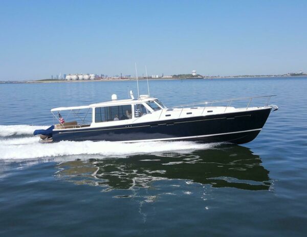 MJM 50z Starboard Side Cruising – Smooth Water MJM 50z cruising on smooth water from the starboard side with an American flag and tender visible on the stern.