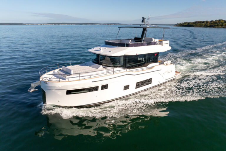 Forward port-side view of Sirena 48 flybridge cruising through green waters.