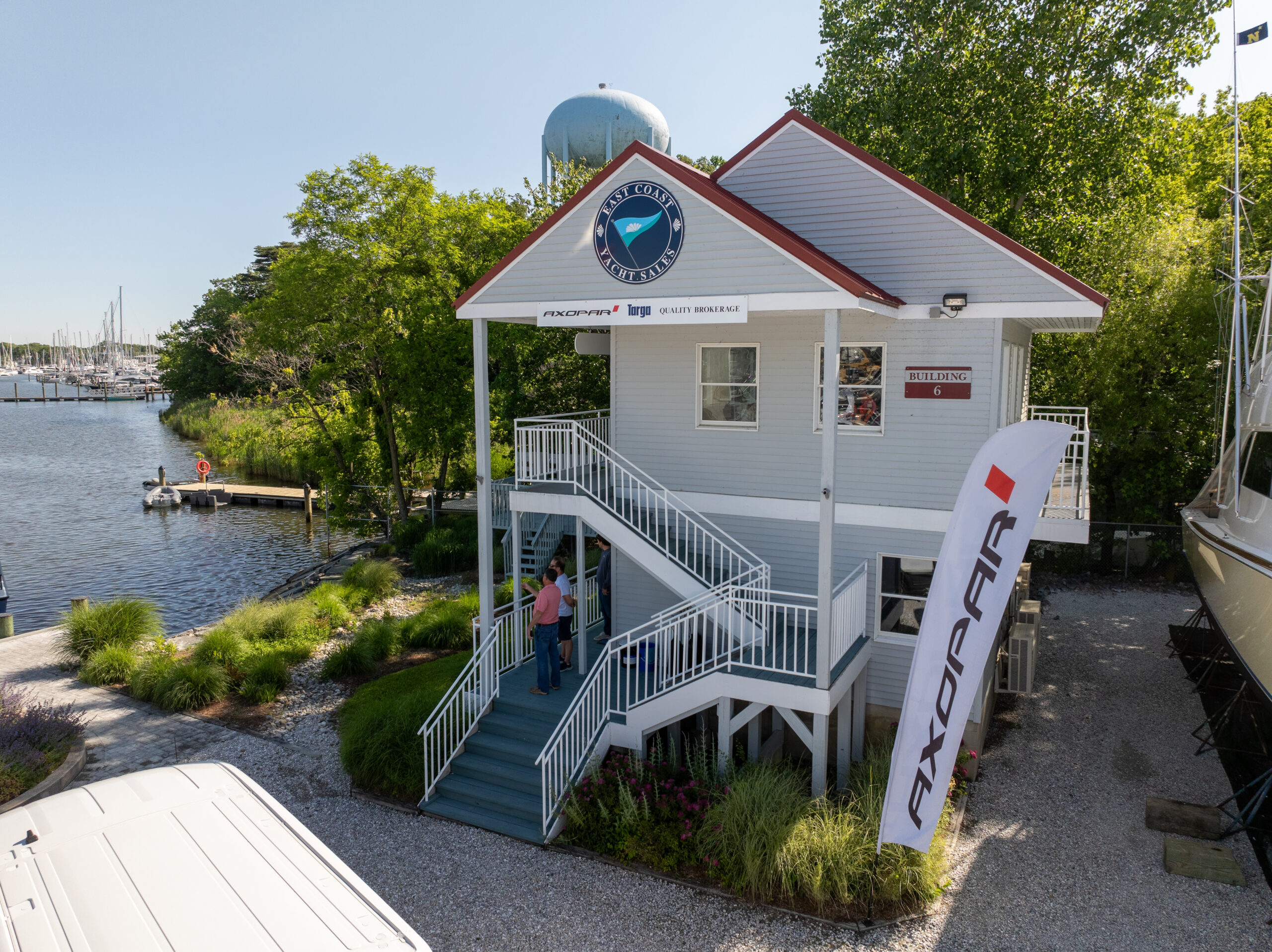 East Coast Yacht Sales Annapolis Office – Building 6 East Coast Yacht Sales Annapolis office, Building 6, with signage and an Axopar feather flag out front, showing a small portion of the harbor in the background.
