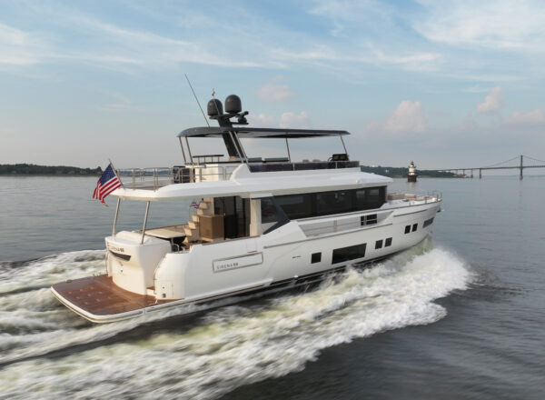 Sirena 68 cruising in Newport, Rhode Island with a flybridge and an American flag flying from the stern.