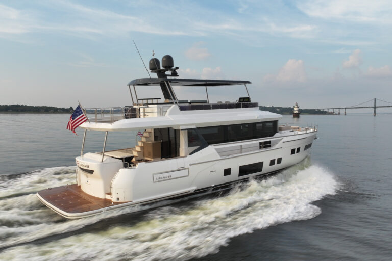Sirena 68 cruising in Newport, Rhode Island with a flybridge and an American flag flying from the stern.