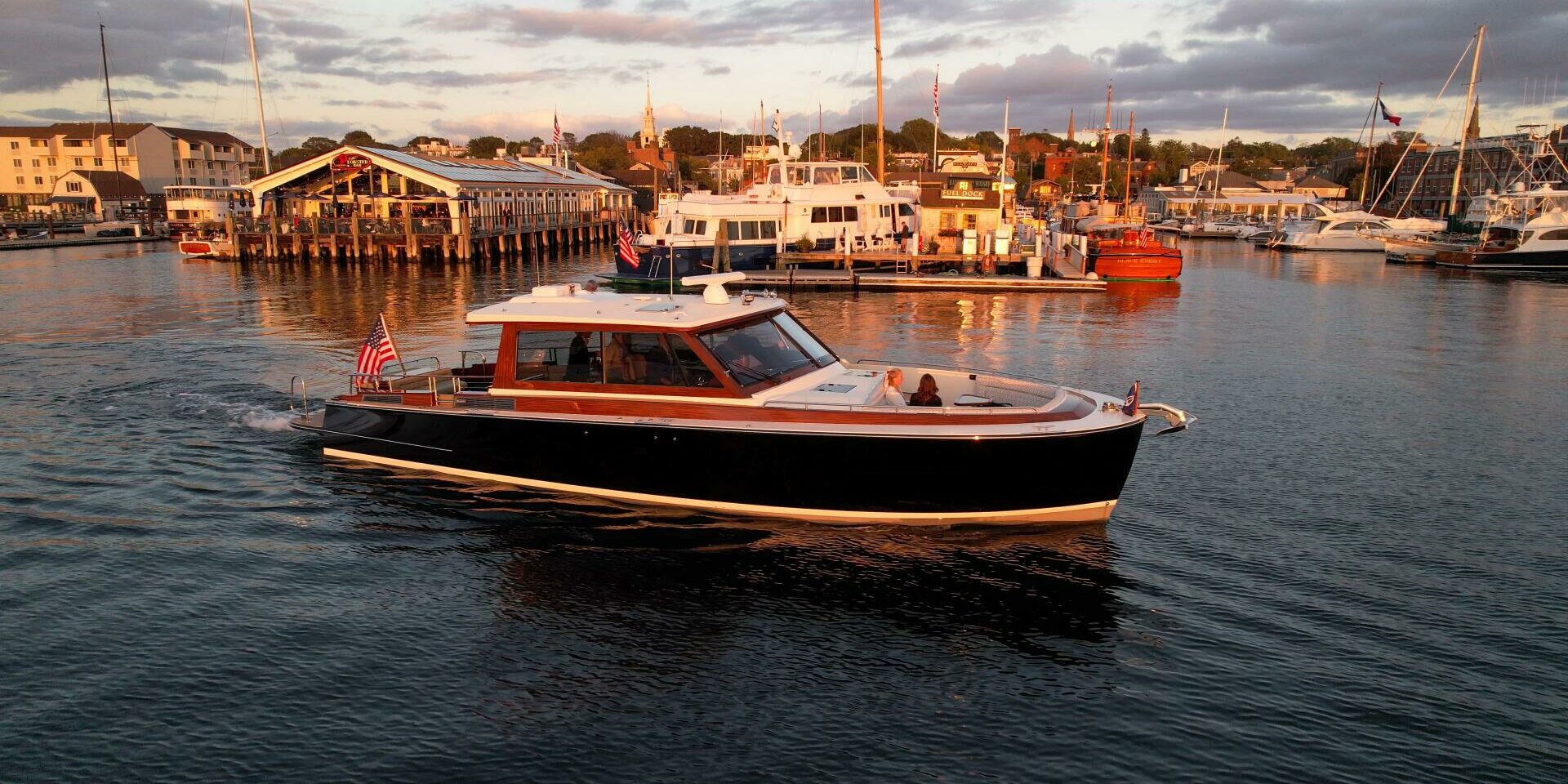 2024 Boston Boatworks 48’ Daychaser slowly cruising through a harbor at golden hour.