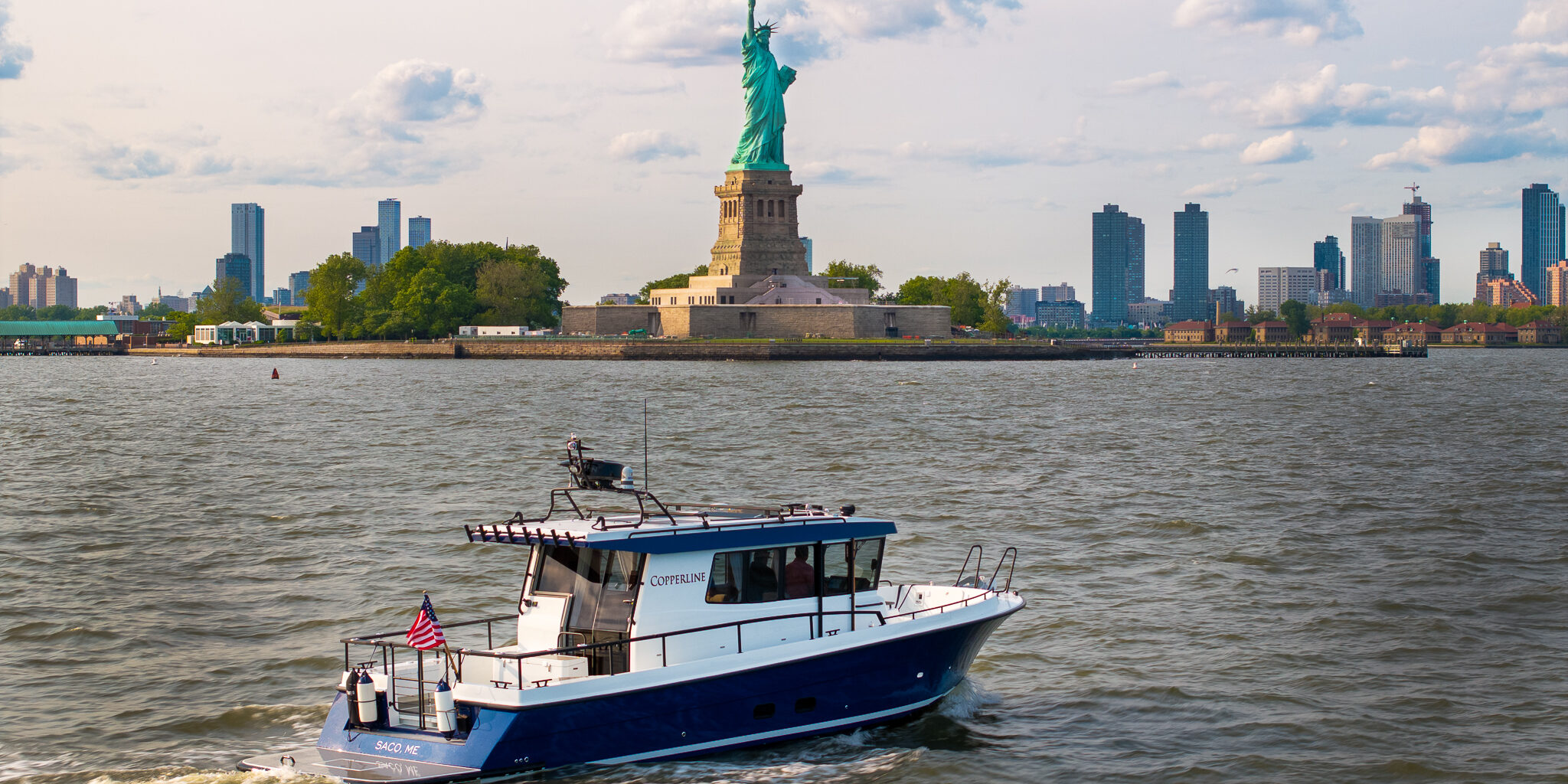 Targa 37 cruising in New York Harbor with the Statue of Liberty in the background.