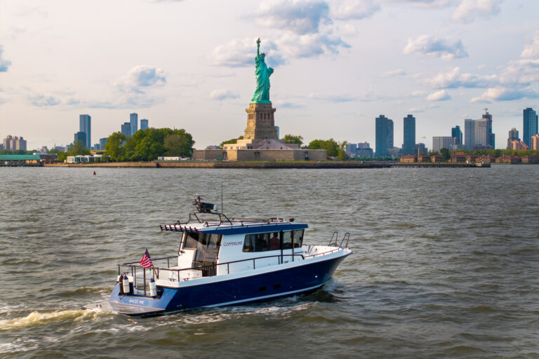 Targa 37 cruising in New York Harbor with the Statue of Liberty in the background.