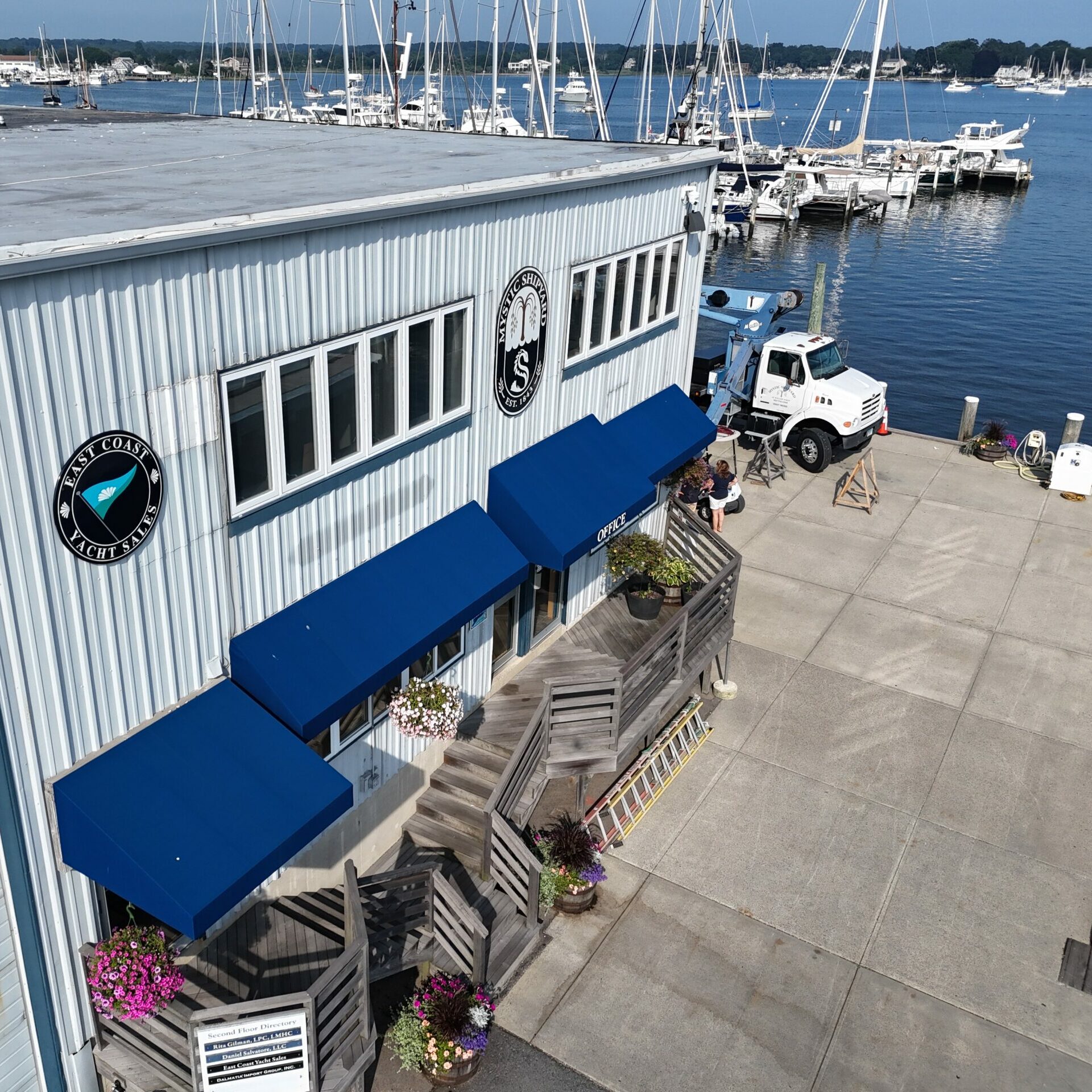 Aerial view of East Coast Yacht Sales Mystic, Connecticut office entrance with harbor and boats in the background.
