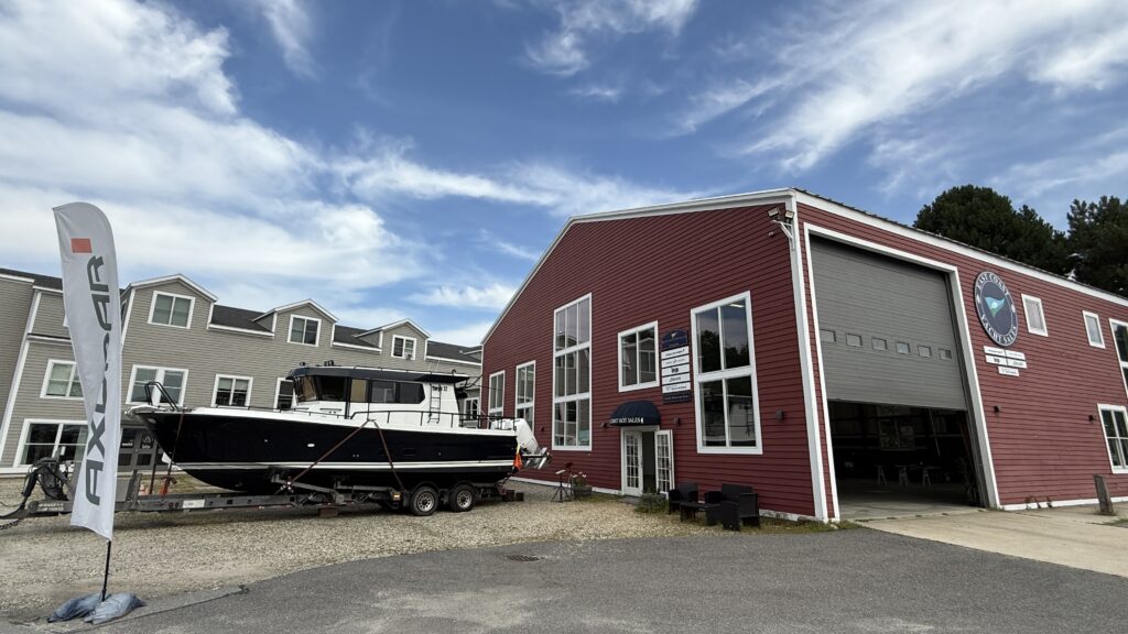 East Coast Yacht Sales Yarmouth, Maine office with showroom door slightly open and a Targa 32 Outboard on a trailer out front, preparing for the Maine Homes & Harbors Boat Show 2025.