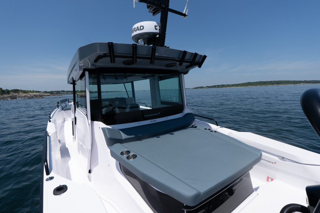 Aft cabin sunpad with Petrol upholstery on a BRABUS Edition Axopar 29 XC Cross Cabin, with dark BRABUS roof accents and rod holders visible while floating offshore in Maine.