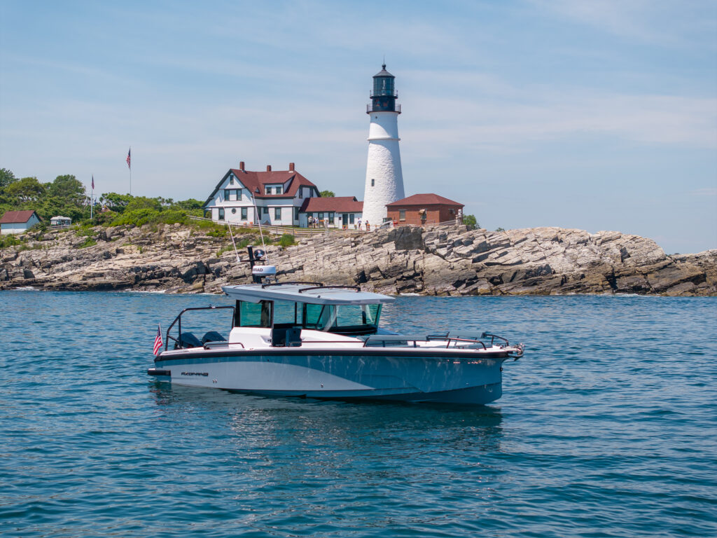 Axopar 29 XC Cross Cabin Platinum Grey in foreground, Portland Headlight in background