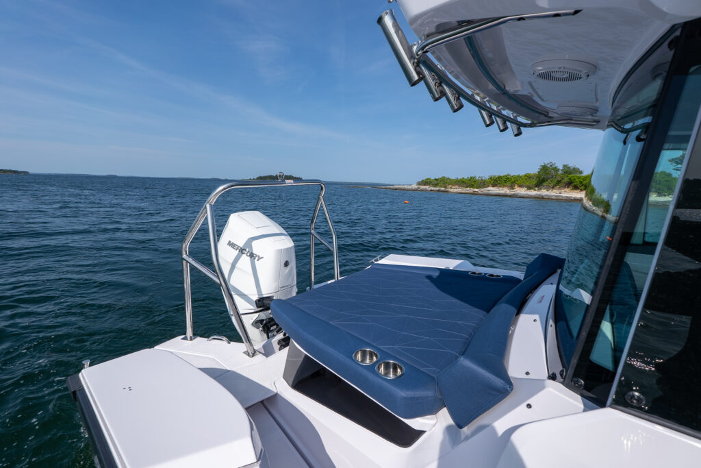 Aft cabin sunpad with Sphere upholstery on an Axopar 29 XC Cross Cabin, shown beside a stainless-steel ski tow bar and single Mercury V10 Verado outboard in Casco Bay, Maine.