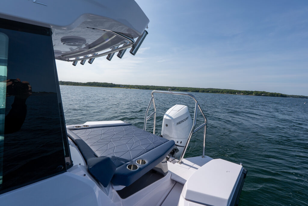 Aft cabin sunpad of an Axopar 29 with Sphere upholstery, shown alongside a single Mercury V10 Verado outboard while anchored in Casco Bay, Maine.