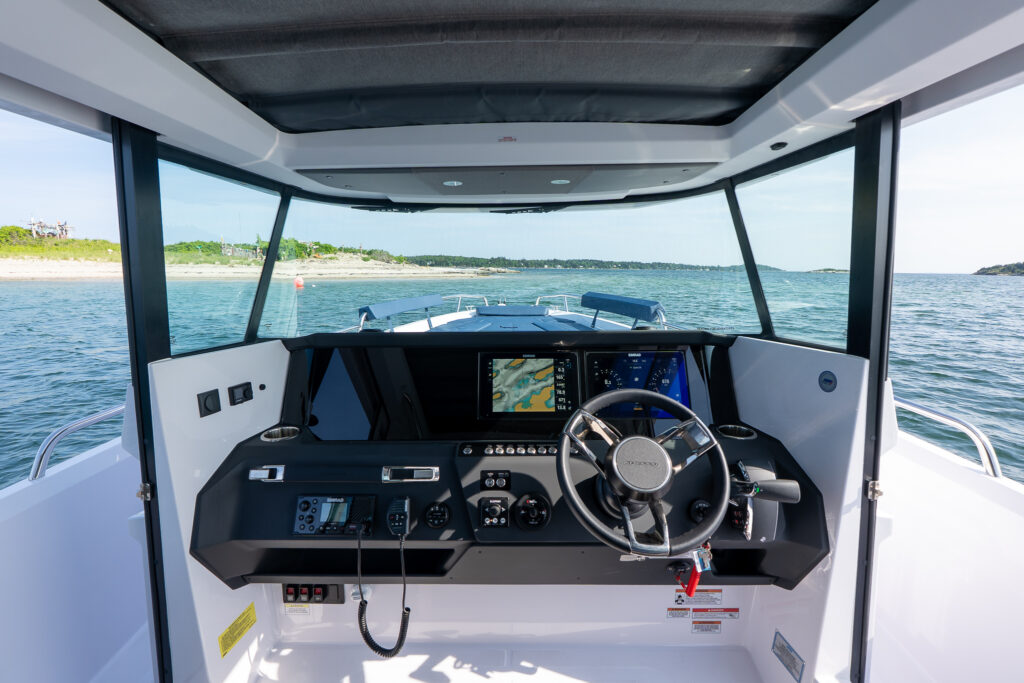 Wide shot of Axopar 29 Stock 34 cockpit with open cabin doors and forward bow seating in Sphere upholstery