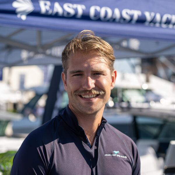 Headshot of Nate Richards, Yacht Consultant based in Yarmouth, Maine, taken at the Newport International Boat Show 2025 with the East Coast Yacht Sales tent in the background.