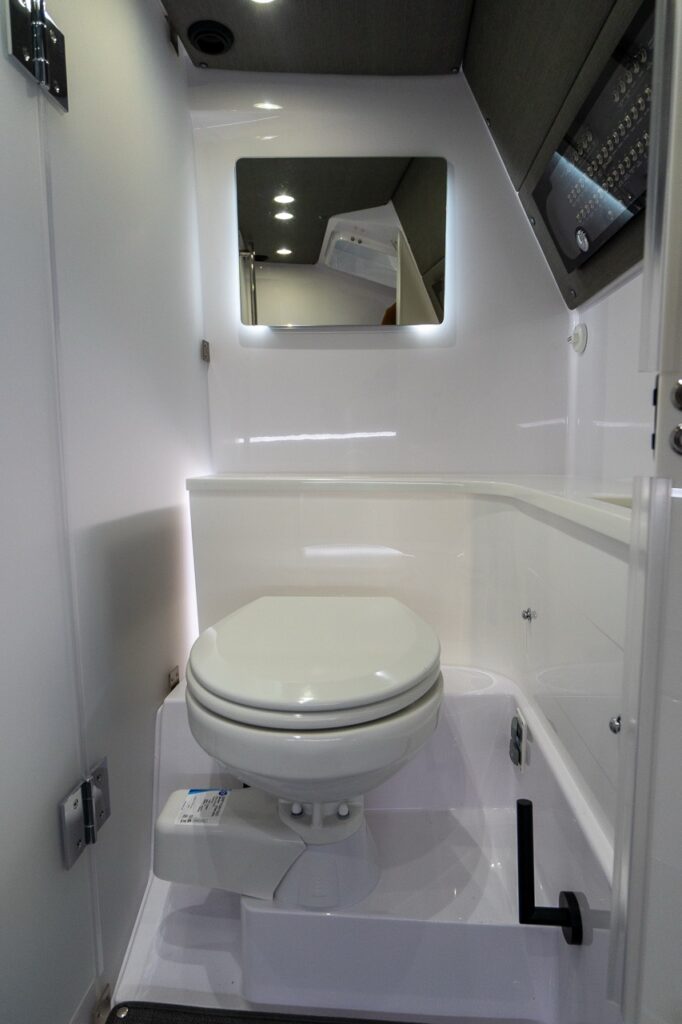 Axopar 37 XC enclosed head compartment with marine toilet and backlit mirror.