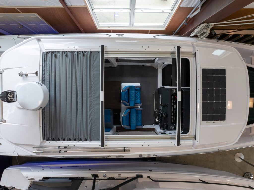 Top-down view of an Axopar 37 XC Cross Cabin pilothouse roof with the canvas sunroof open and a solar panel mounted on the pilothouse roof.