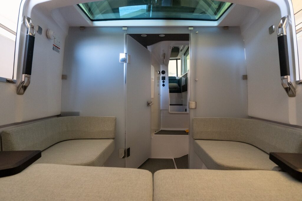 Forward cabin of an Axopar 37 XC Cross Cabin with twin bench seating and the head door positioned to close the head while keeping the main cabin open toward the companionway.