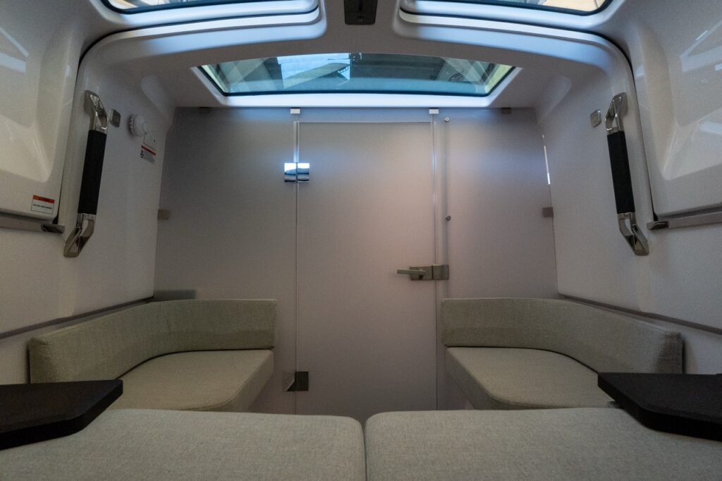Forward cabin seating area in an Axopar 37 XC Cross Cabin with the enclosed head compartment door closed and overhead skylight windows.