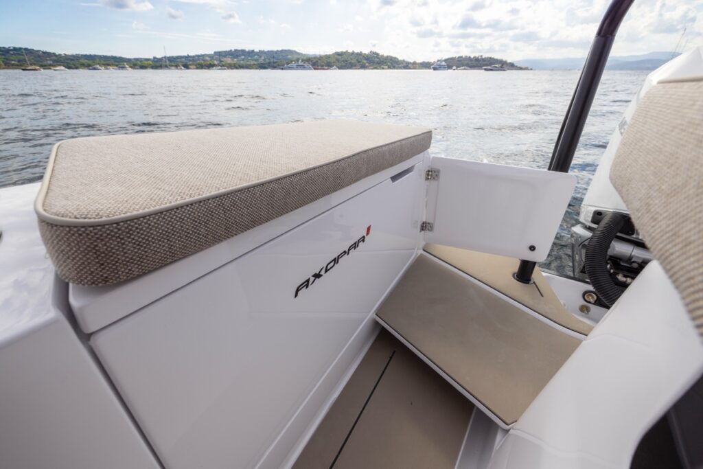 Axopar 37 XC fender box with Mediterrana upholstery cushion beside the aft gate, showing the transom step and water view.
