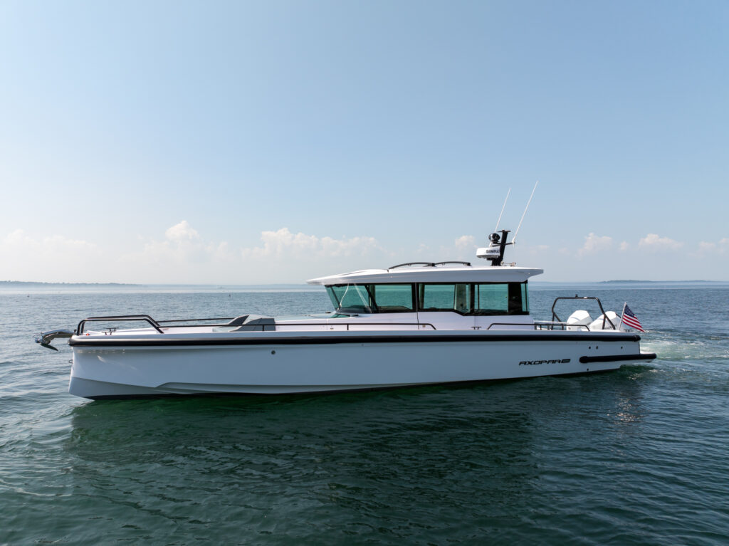 Axopar 37 XC Cross Cabin BRABUS edition idling in a calm ocean with islands barely visible in the distance