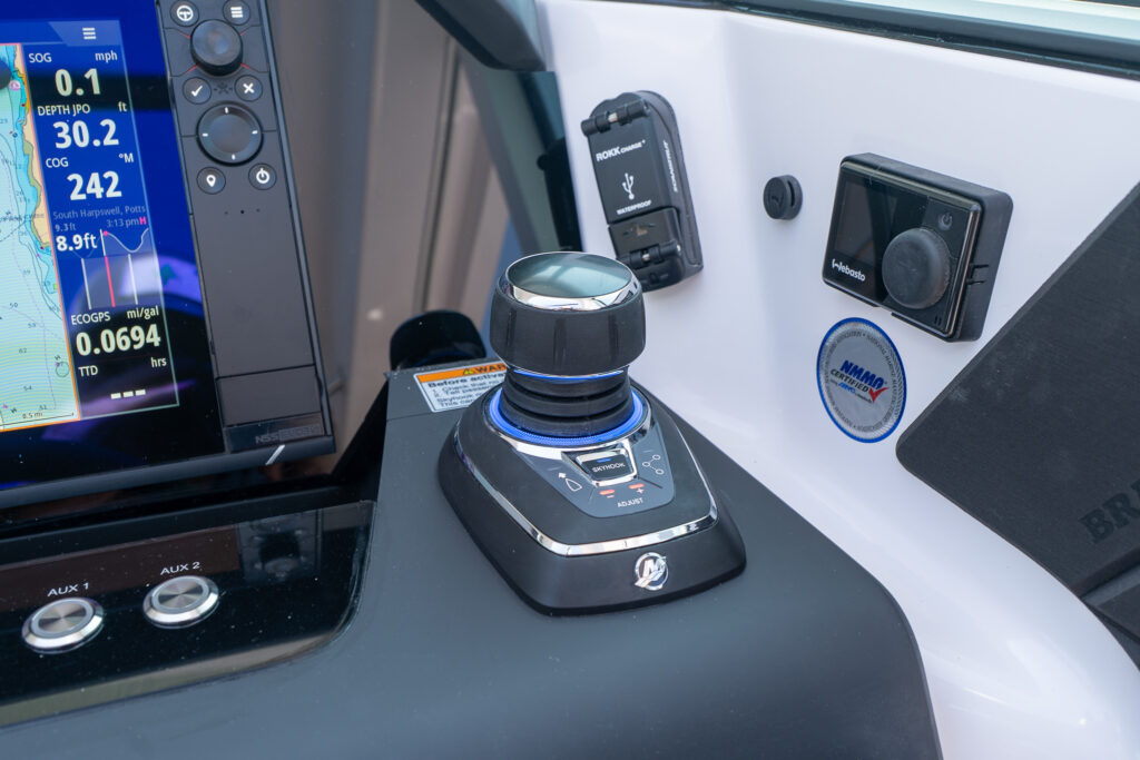 Close-up of the Mercury joystick piloting system on an Axopar 37, shown beside a Simrad display, USB charging port, and Webasto control panel.