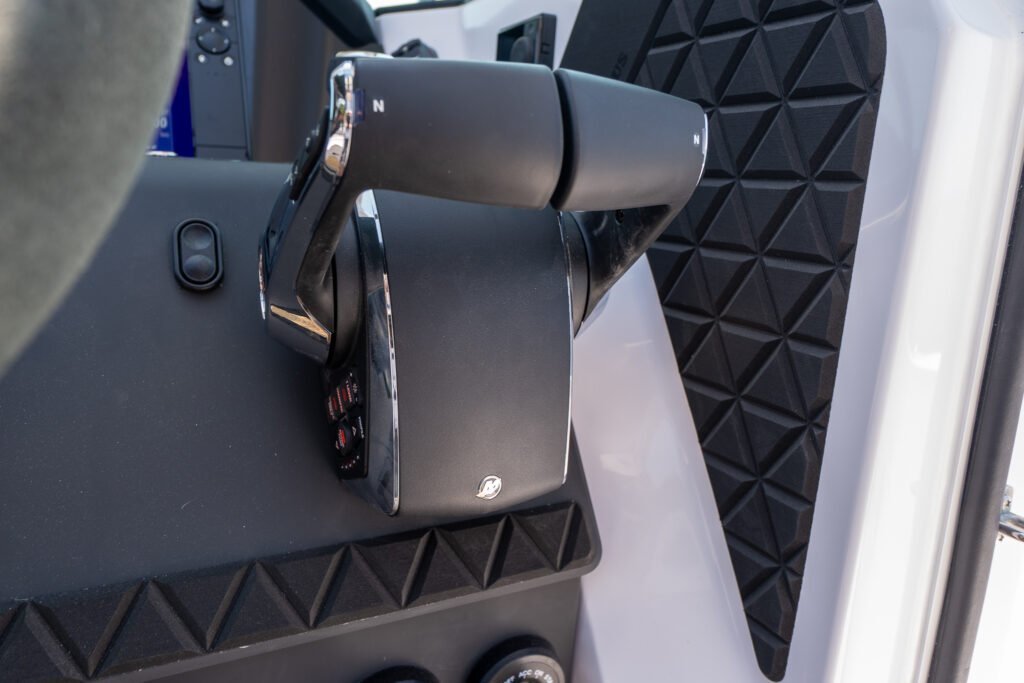 Close-up of the Mercury throttle and shift controls on an Axopar 37, featuring dual levers with neutral indicators and textured grip surfaces.