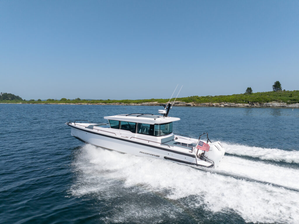 Axopar 37 cruising at speed along the Casco Bay coastline on a clear day.