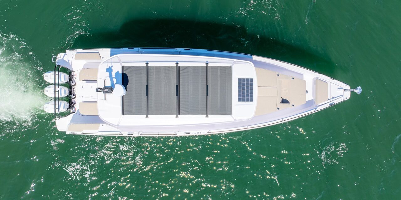 Top-down aerial view of an Axopar 45 BRABUS Performance Line with triple outboards cruising on green water in Casco Bay, Maine.