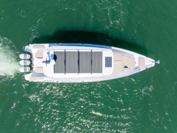 Top-down aerial view of an Axopar 45 BRABUS Performance Line with triple outboards cruising on green water in Casco Bay, Maine.