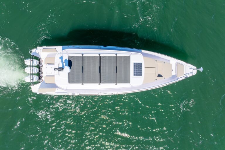 Top-down aerial view of an Axopar 45 BRABUS Performance Line with triple outboards cruising on green water in Casco Bay, Maine.