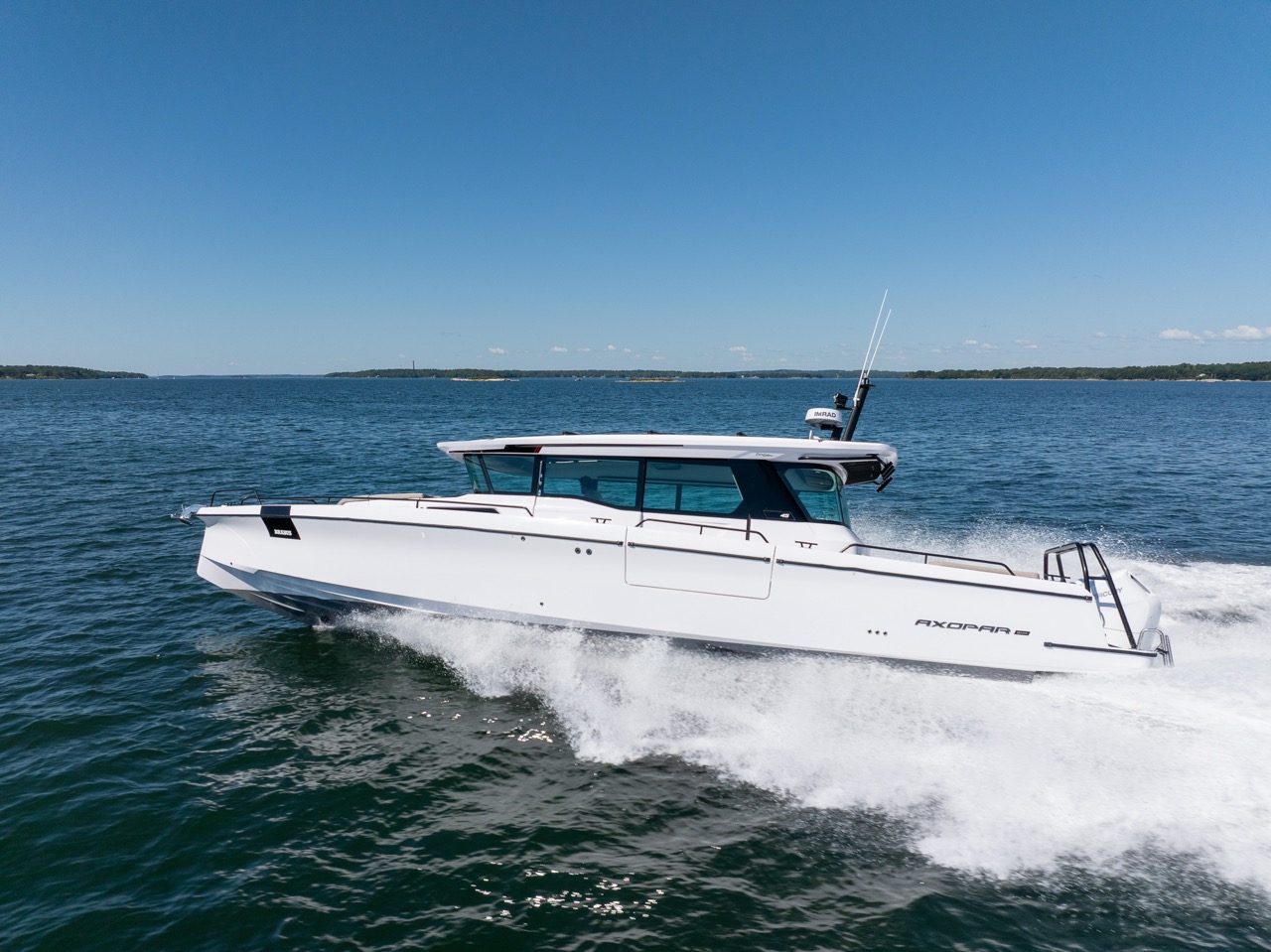 Axopar 45 BRABUS Performance Line running at speed on Casco Bay, Maine, with a white wake and islands on the horizon.