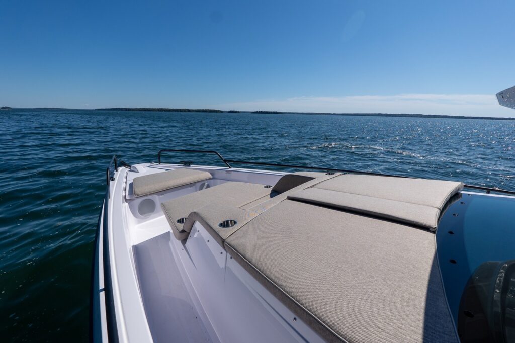Foredeck sunpad and lounge cushions on an Axopar 45 BRABUS Performance Line with Casco Bay, Maine in the background.