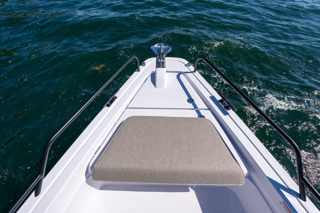 View of the Axopar 45 BRABUS Performance Line bow deck with sunpad cushion, anchor, and rails over open water in Casco Bay, Maine.