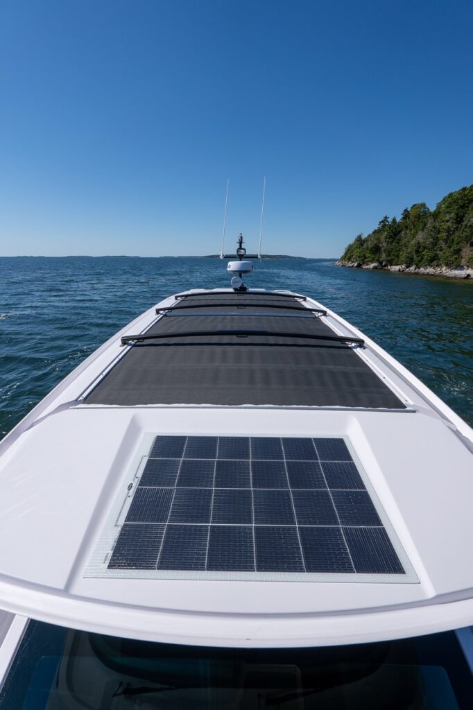 Top-deck view of an Axopar 45 BRABUS Performance Line showing the roof-mounted solar panel and retractable sunroof while cruising in Casco Bay, Maine.