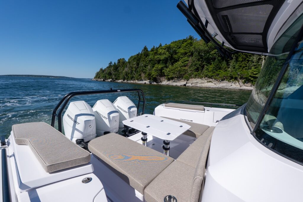Axopar 45 BRABUS Performance Line aft deck with a U-Sofa, cockpit table, and triple Mercury Verado 350 outboards in Casco Bay, Maine.