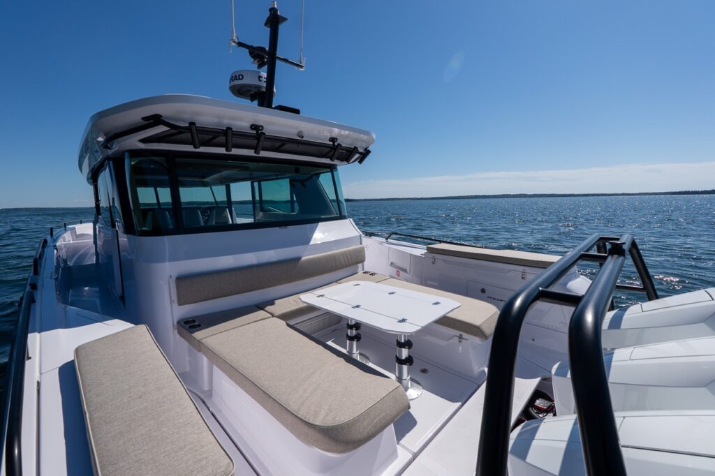 Axopar 45 BRABUS Performance Line cockpit with U-Sofa seating and table, with triple Mercury Verado 350 outboards at the stern on Casco Bay, Maine.