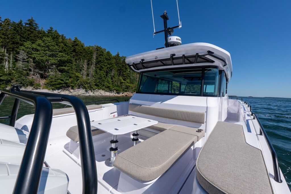 Axopar 45 BRABUS Performance Line U-Sofa cockpit with wraparound seating and dining table underway in Casco Bay, Maine.