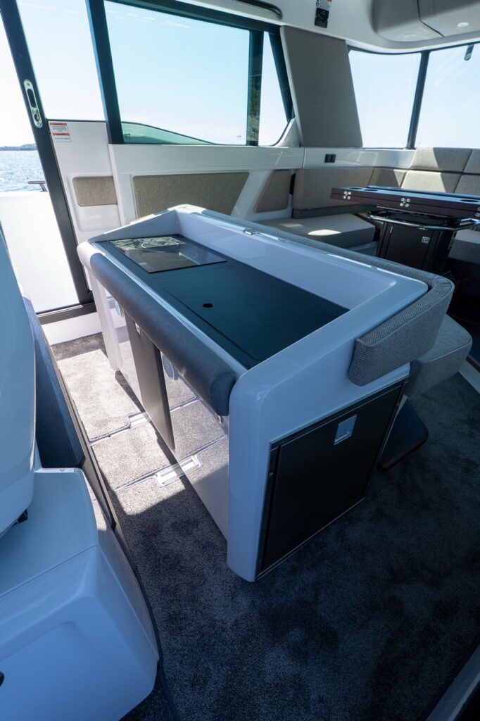Cabin galley module on an Axopar 45 BRABUS Performance Line with integrated cooktop, countertop workspace, and under-counter refrigerator.