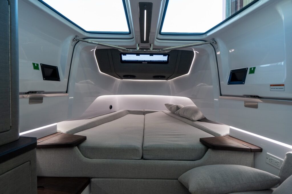 Axopar 37 XC forward cabin with a double berth, ambient LED lighting, and overhead windows that are integrated into the gullwing doors.