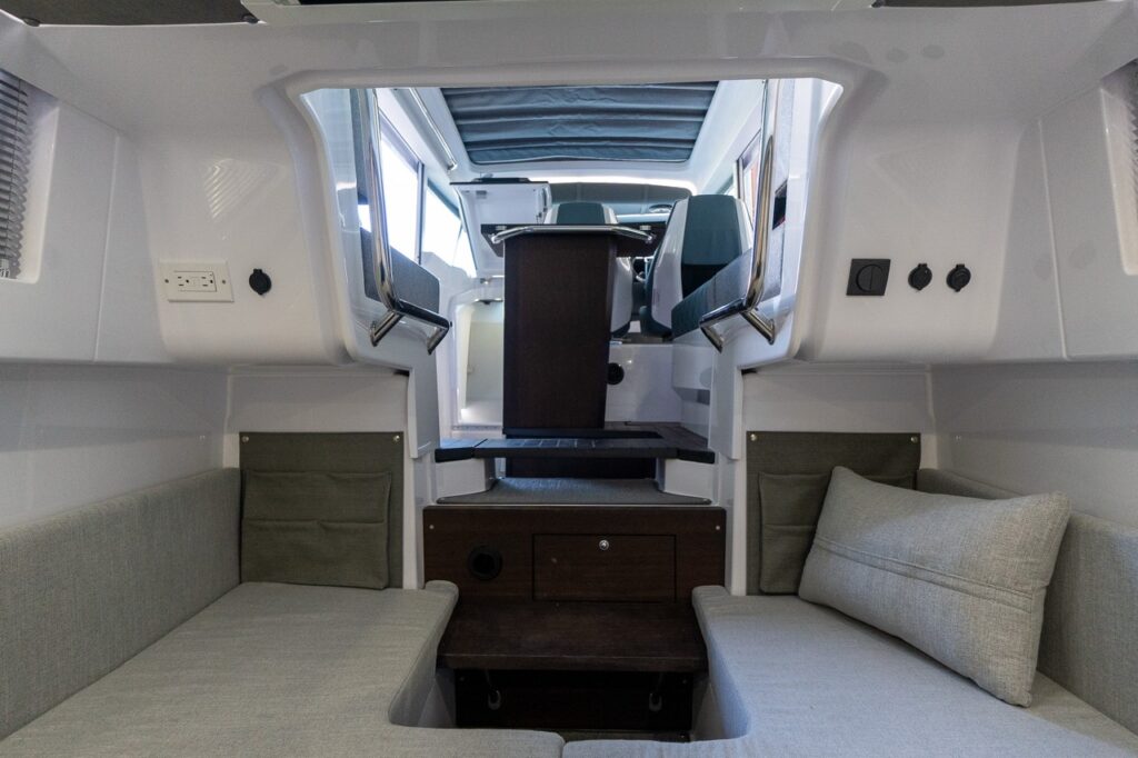 View from the Axopar 37 XC aft cabin lounge looking forward through the entry steps toward the pilothouse seating and helm area.