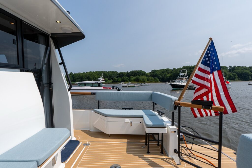 Aft cockpit of the Targa 32 with wraparound seating, teak-style decking, and an American flag at the stern while docked in a marina.