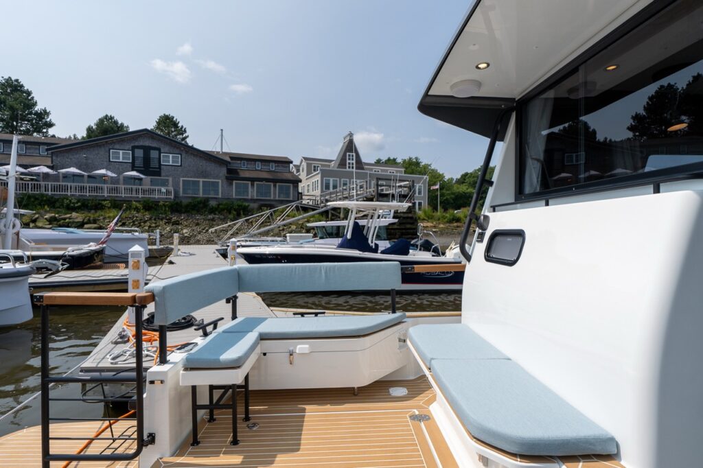 Aft cockpit seating area on the Targa 32 with wraparound bench seating and teak-style decking while docked at a marina.