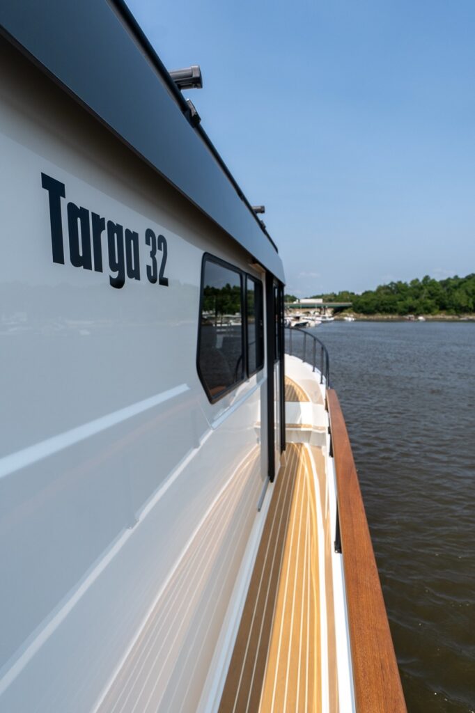 Starboard side deck of the Targa 32 showing the hull-side walkway with teak-style decking and the “Targa 32” model designation on the cabin side.