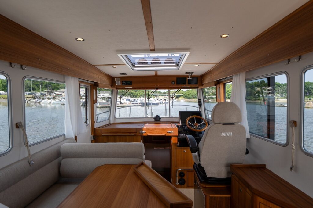 Wide interior view of the Targa 32 pilot house showing the helm, portside dinette, skylight, and wraparound windows.
