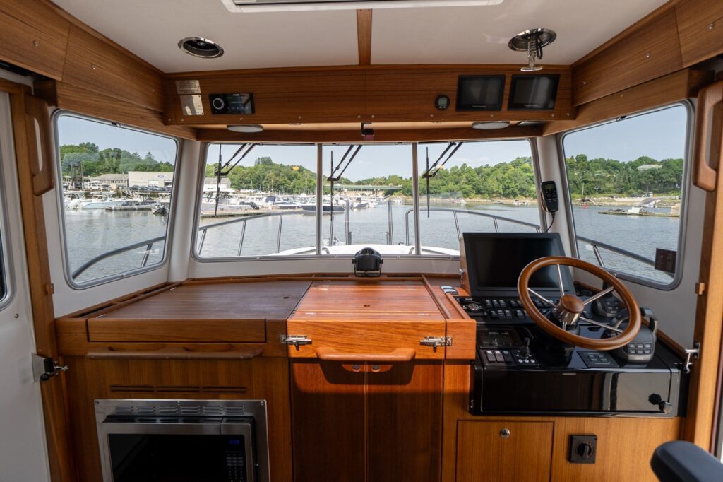 Targa 32 pilot house with forward galley worktop to port and helm station to starboard, framed by large panoramic windows.