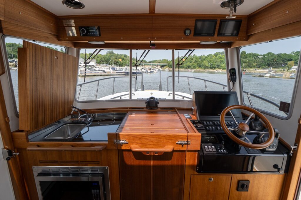 Targa 32 pilot house showing the helm station to starboard and galley to port with panoramic forward windows.