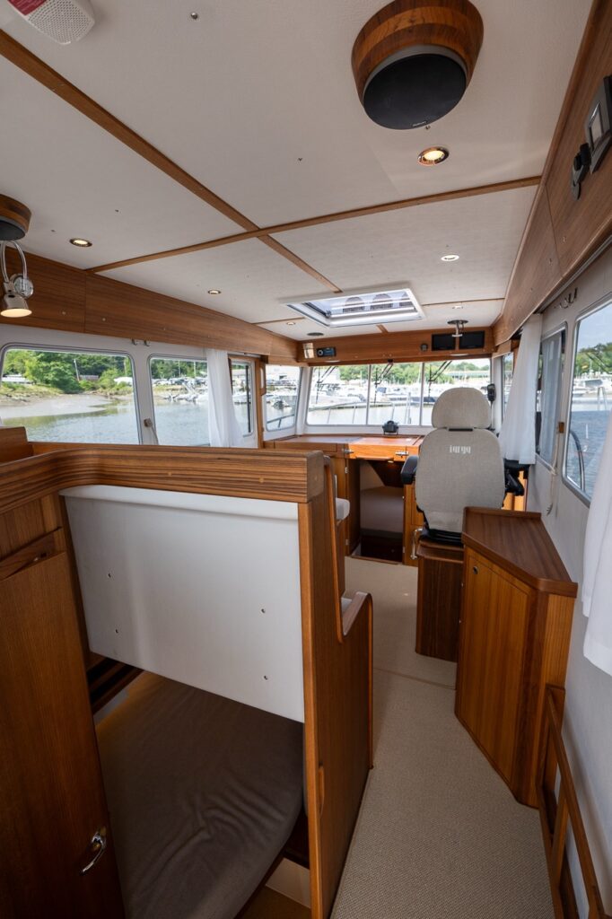 Pilot house interior of the Targa 32 with teak joinery, forward helm position, and clear walk-through layout.