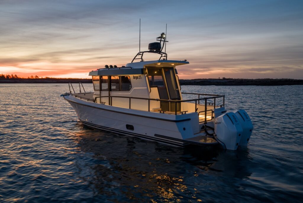 Aft quarter view of a Targa 27.2 Coupe at sunset, highlighting its enclosed pilothouse, extended roof overhang, wide aft deck, protective railings, and twin outboard power.