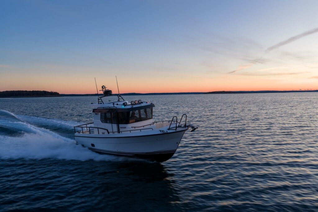 Targa 27.2 Coupe running underway at sunset, highlighting its enclosed pilothouse, sharp entry bow, deep-V hull, and stable running attitude on open water.