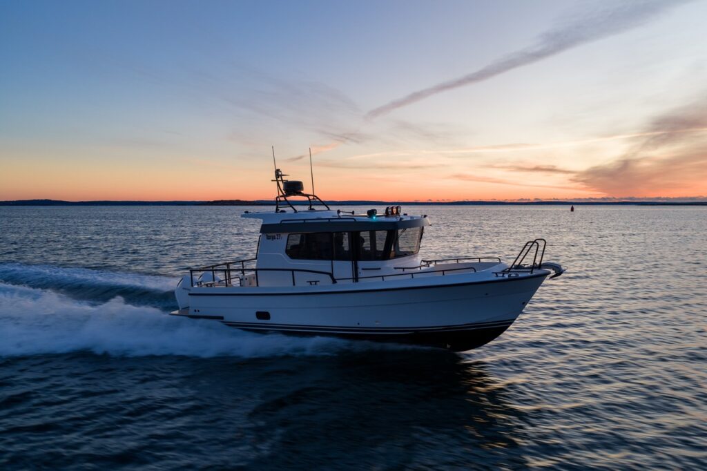 Side running profile of a Targa 27.2 Coupe underway at sunset, emphasizing its sharp bow entry, deep-V hull, enclosed pilothouse, and stable running attitude.
