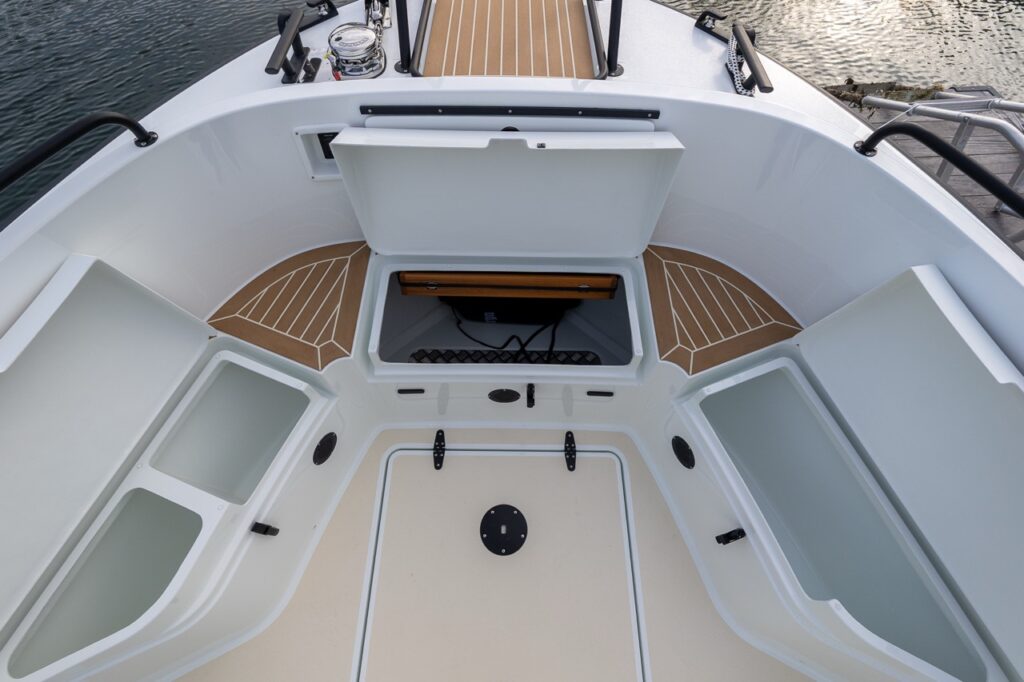 Forward deck of a Targa 27.2 Coupe with an open central storage hatch, showing symmetrical bench seating, teak-style deck inlays, non-skid surfaces, and integrated hardware at the bow.